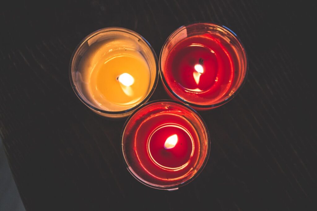 Three colorful candles burning brightly, providing a cozy and warm ambiance. Perfect for relaxation.